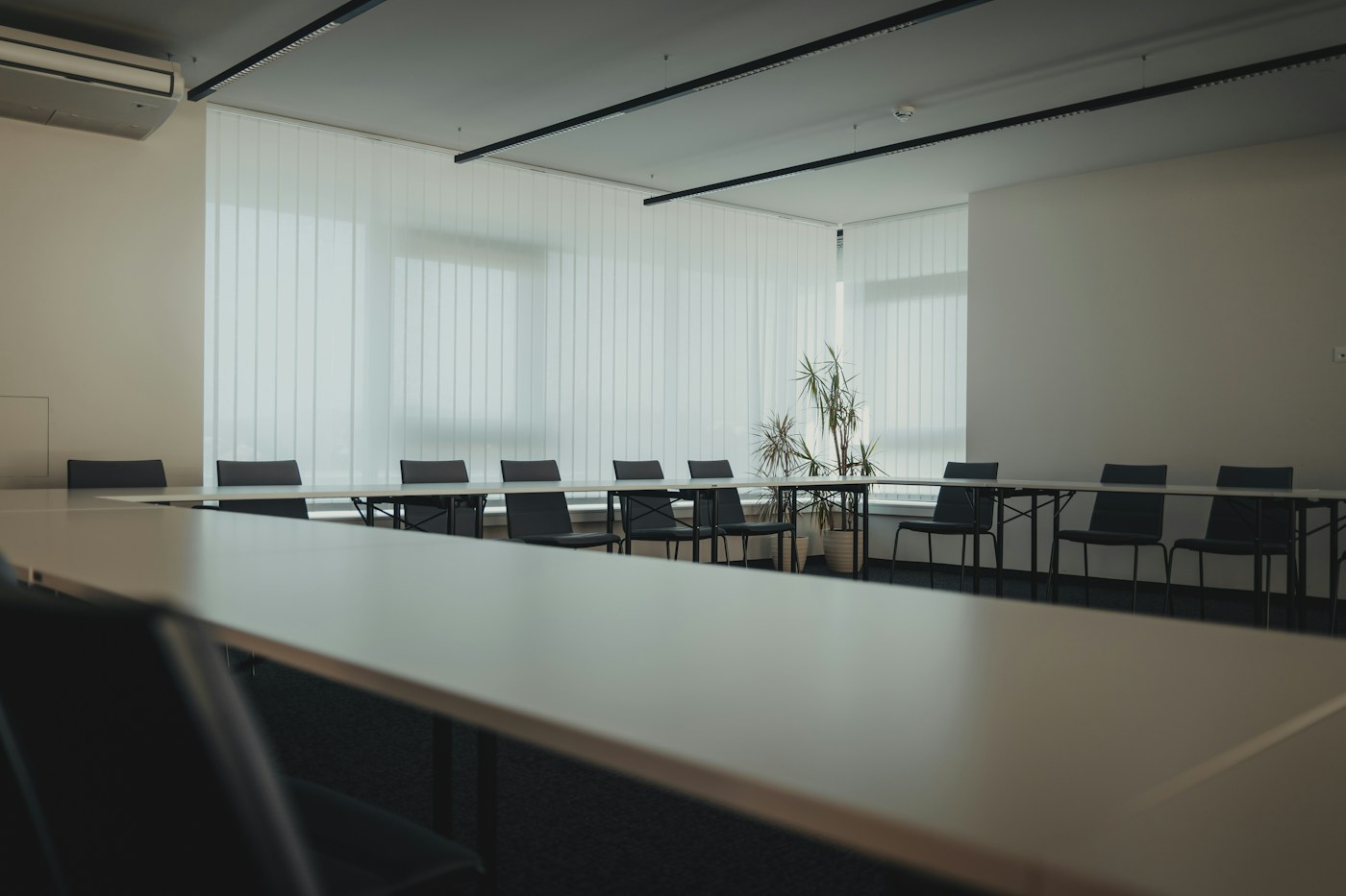 Quiet meeting room with a white table and black chairs